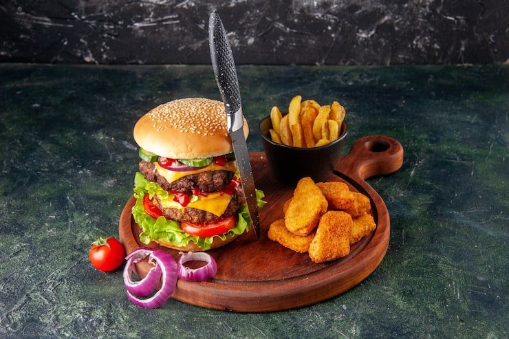 tasty-homemade-sandwich-tomatoes-pepper-wooden-cutting-board-onions-tomato-with-stem-chicken-nuggets-fries-fork-dark-color-surface_179666-34113